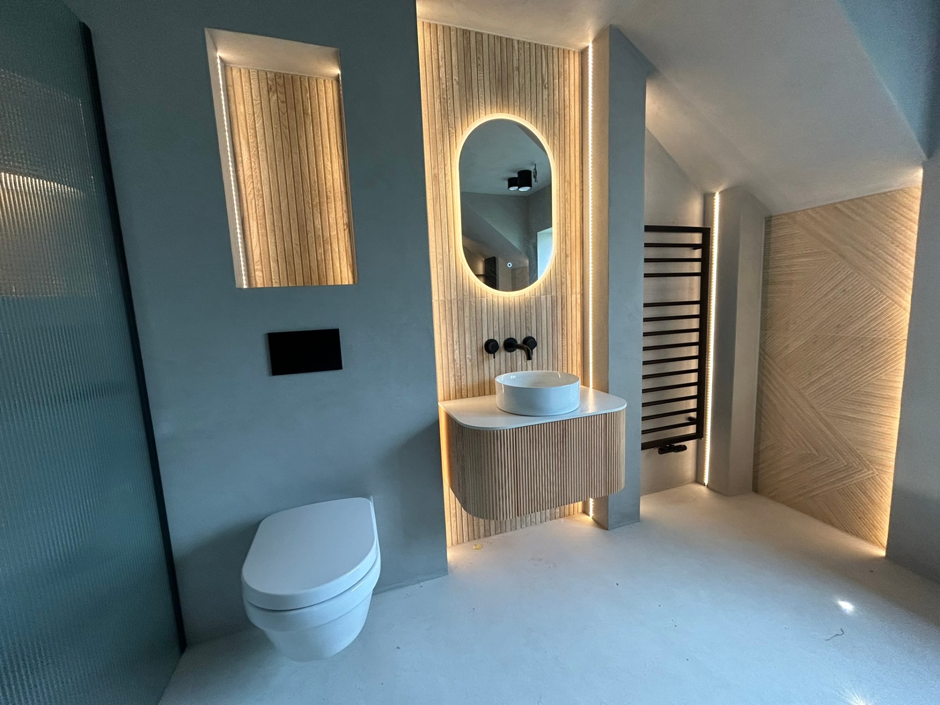 Wide-angle microcement bathroom with walk-in shower and vanity