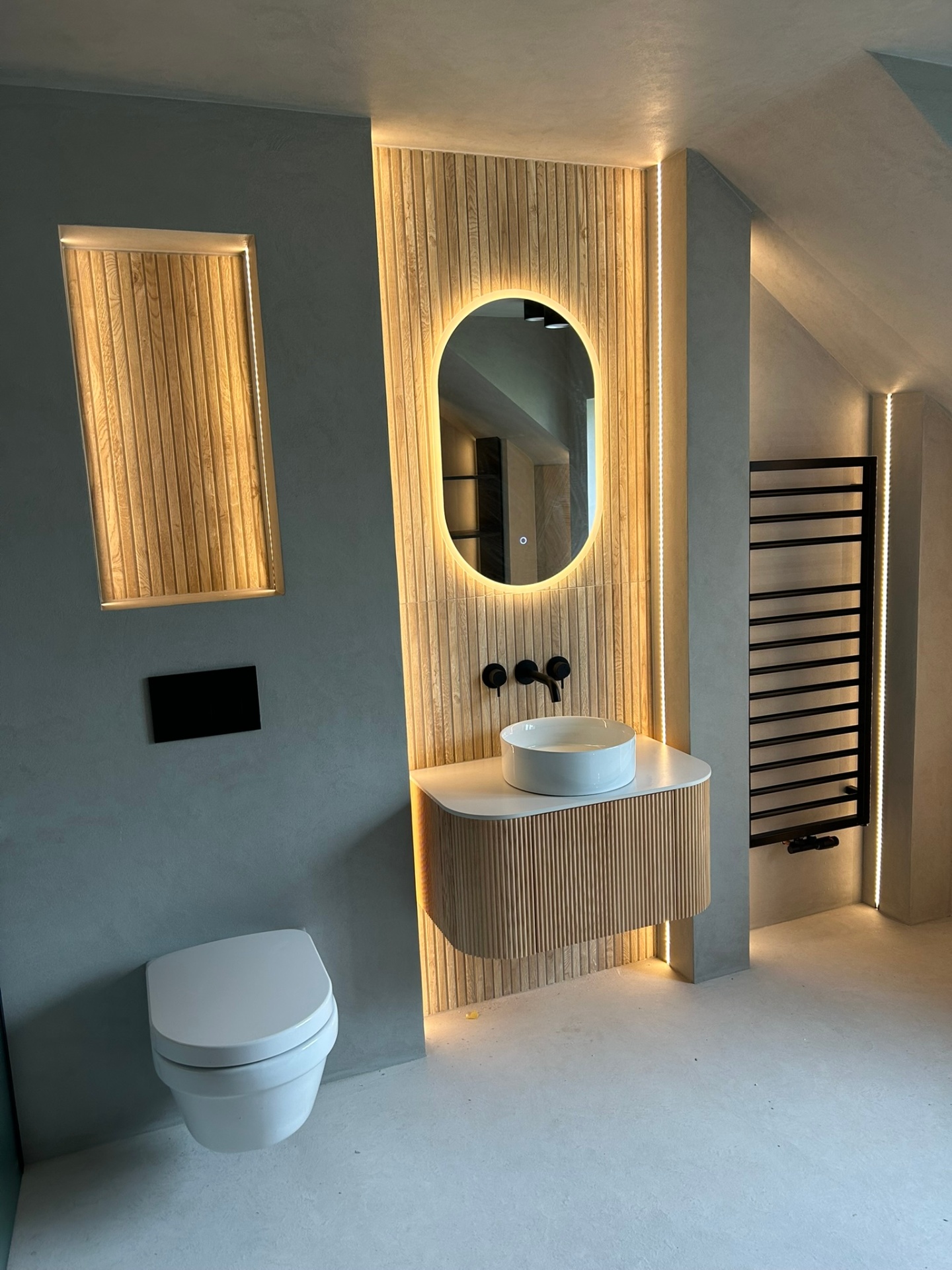 Microcement loft bathroom with vanity, WC, and heated towel rail