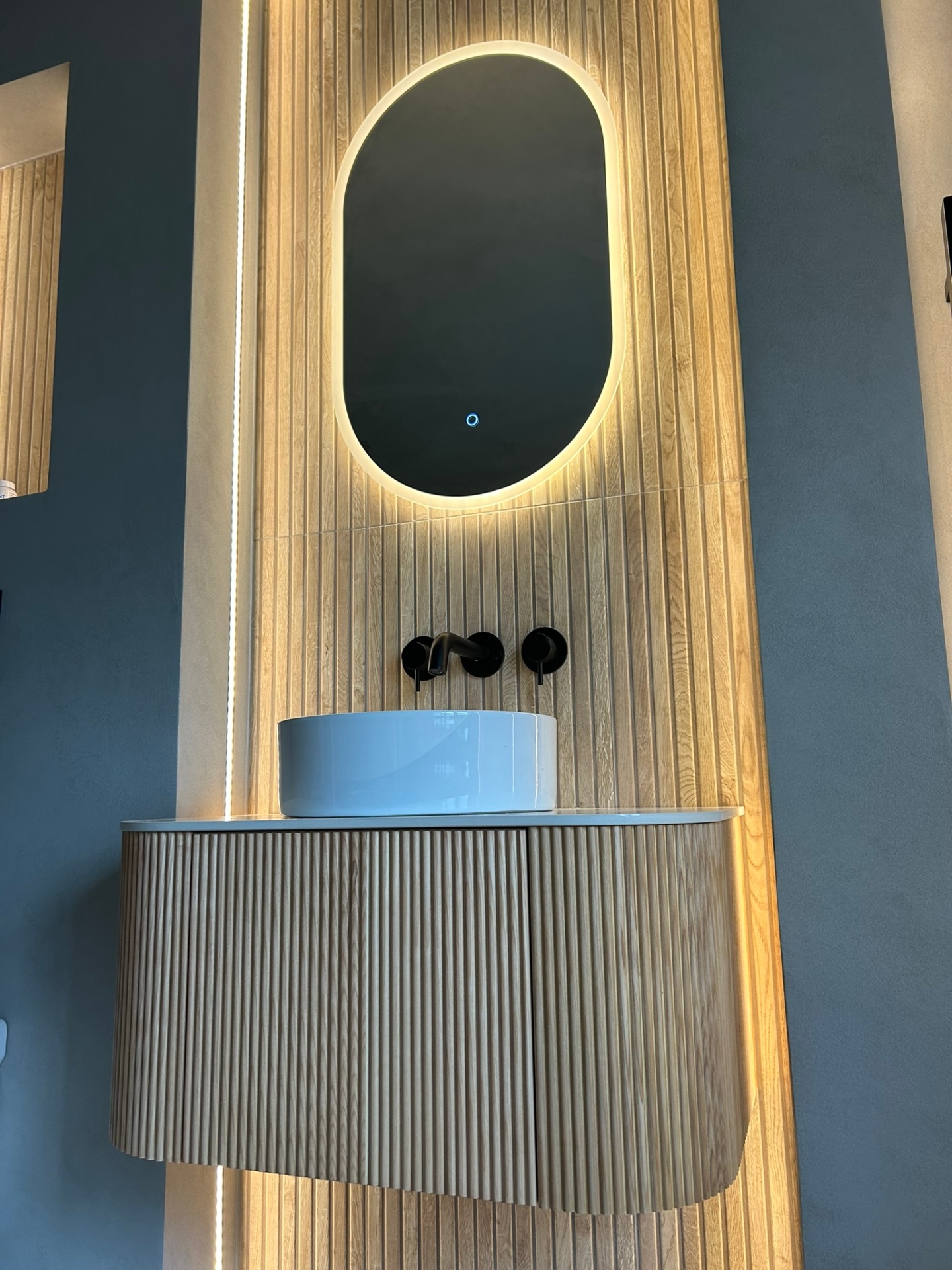 Fluted vanity unit with vessel basin and black wall-mounted taps