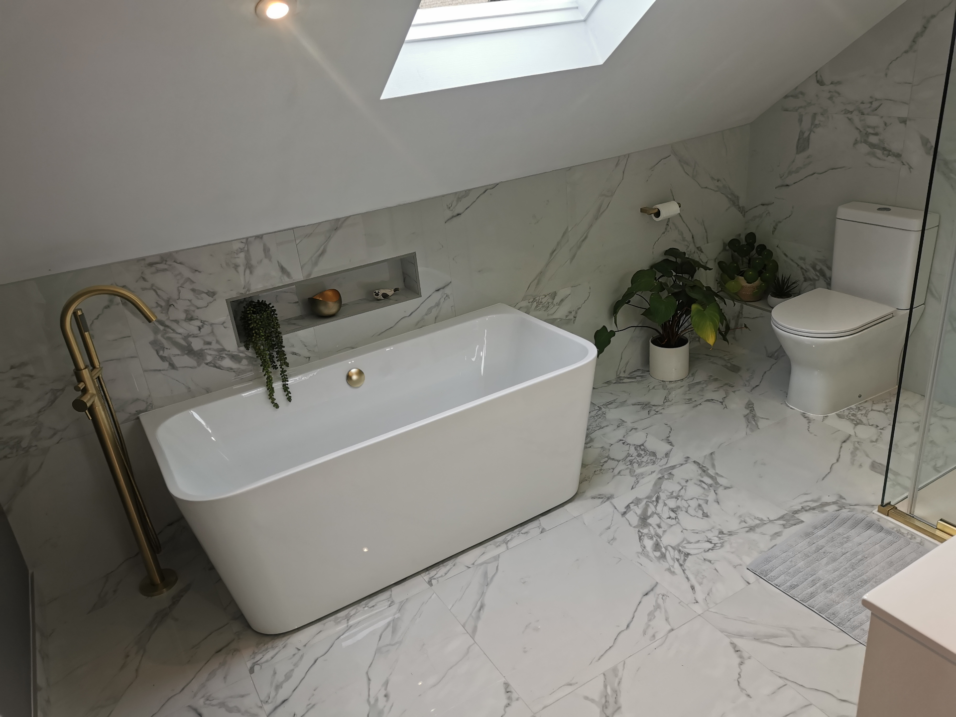 Luxury marble bathroom with freestanding bath and brass fittings