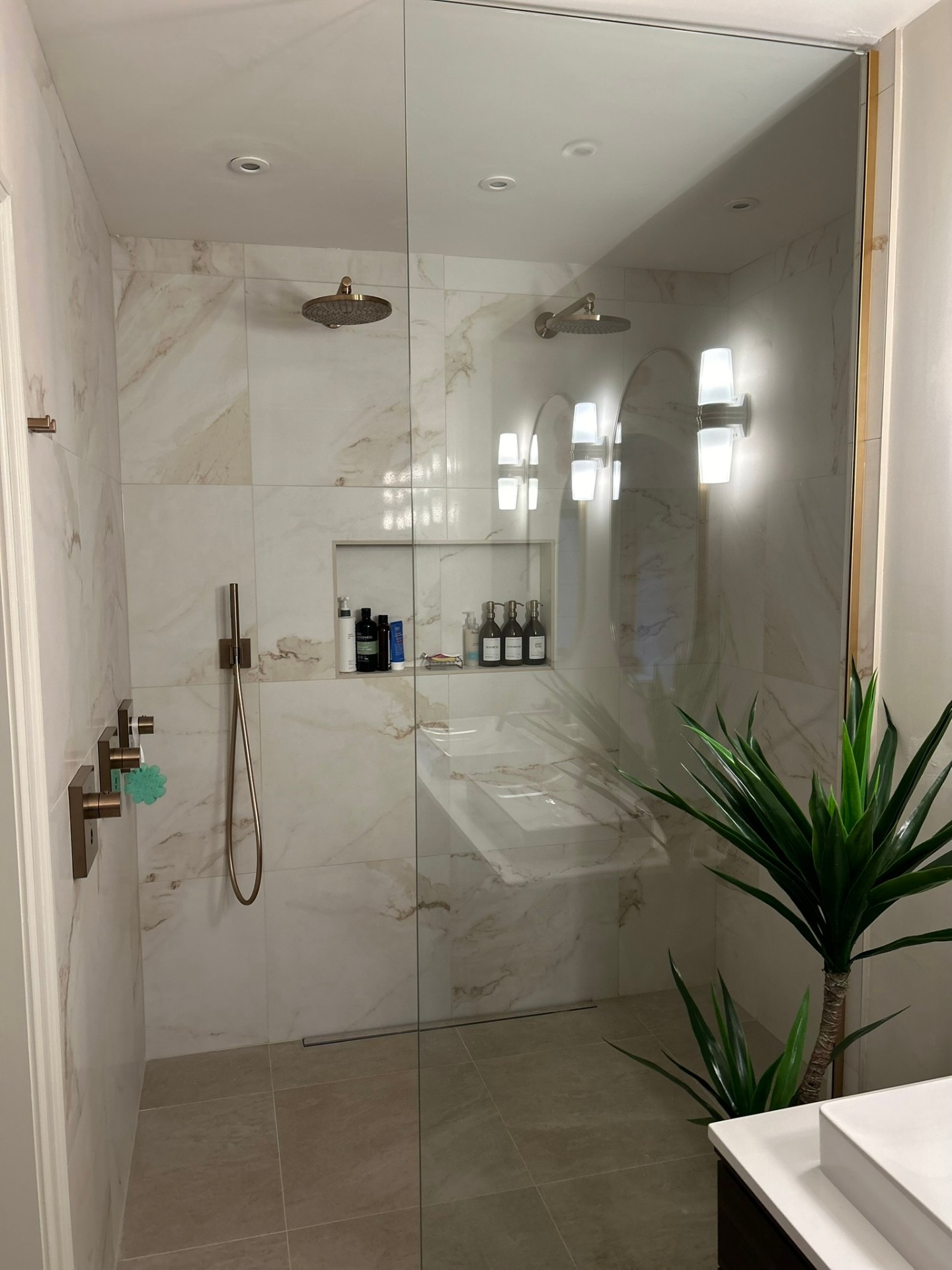 Large marble-effect walk-in shower with recessed niche